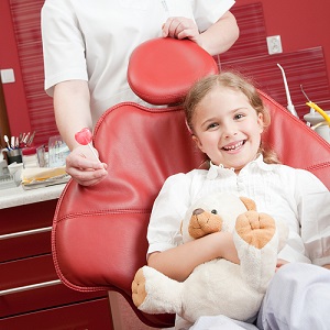 Girl in a dental chair smiling.